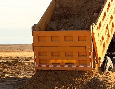 Ein Lkw Kipper entlädt die Sand